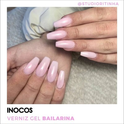 Mãos com unhas quadradas de verniz gel rosa bailarina brilhante