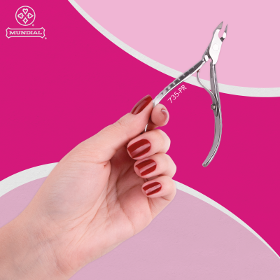 Mão segurando cortador de cutículas metálico prateado com unhas vermelhas