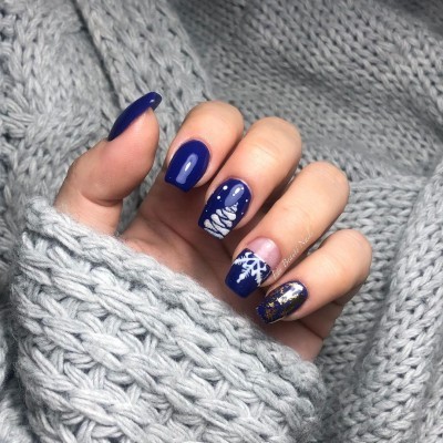 Unhas quadradas azuis com desenhos de Natal e fundo de malha cinza