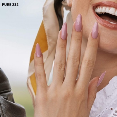 Mão feminina com unhas acrílicas rosa fosco e rosto sorridente ao fundo