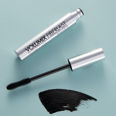 Máscara de pestanas VOLUMIX FIBERLAST da L'ORÉAL, aplicador e amostra de produto preta em fundo azul claro