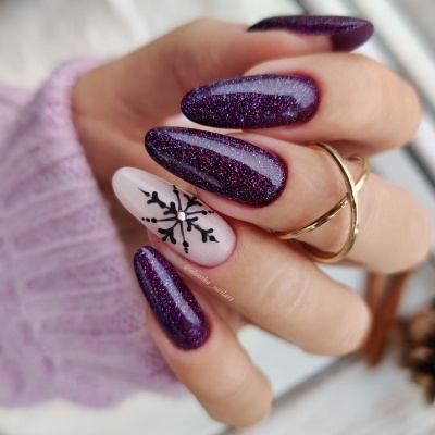 Unhas decoradas roxas com glitter e floco de neve preto em unha nude