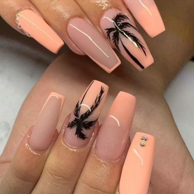Unhas artificiais rosa claro com desenhos de palmeiras preta e pedras decorativas.