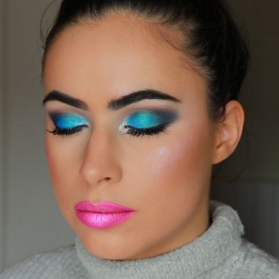 Mulher com maquilhagem vibrante e camisola cinza