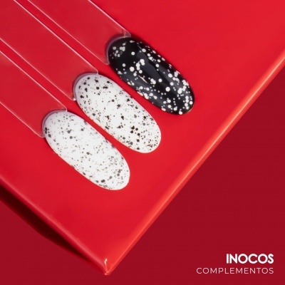 Amostras de verniz para unhas em palitos com padrão em branco e preto sobre fundo vermelho.