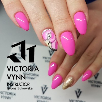 Unhas rosa brilhantes com desenho de flamingo e unha dourada, fundo com logotipo Victoria Vynn