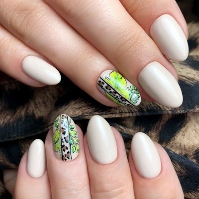 Unhas decoradas com base bege clara e desenhos verdes neons e padrão animal print