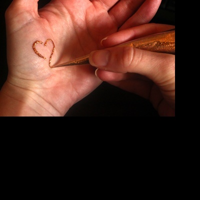 Aplicação de glitter dourado em forma de coração na palma da mão