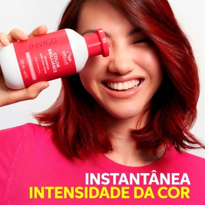Mulher com cabelo vermelho segurando produto INVIGO COLOR BRILLANCE da Wella