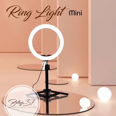Ring Light Mini com luz circular branca sobre base preta em ambiente com espelho e esferas brancas