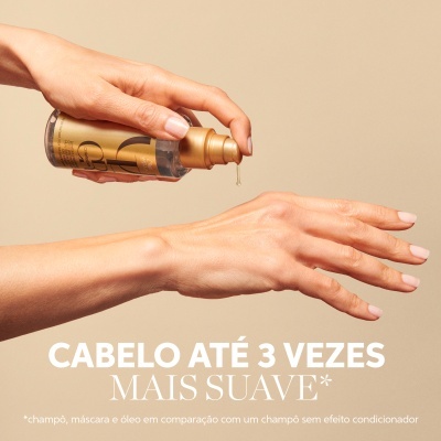 Frasco de cosmético dourado aplicado na mão com fundo bege e texto promocional em português.