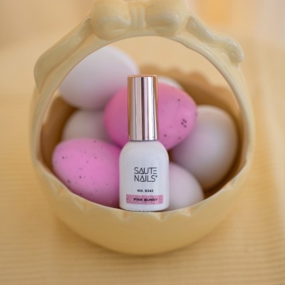 Verniz para unhas SAUTE NAILS dentro de cesto amarelo com ovos cor-de-rosa e brancos