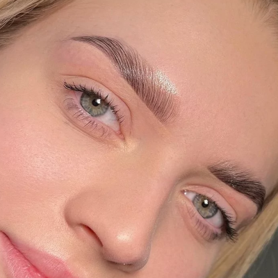 Close-up de rosto feminino com sobrancelhas definidas e olhos verdes