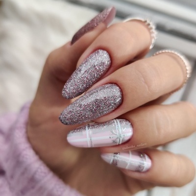 Unhas com glitter prateado e padrão xadrez branco e prateado em fundo rosa claro