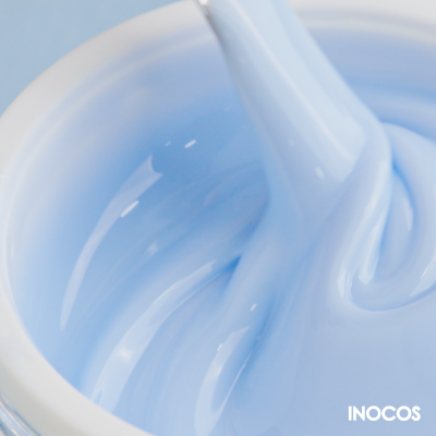 Creme azul claro num frasco branco com espátula