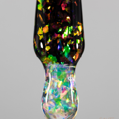 Ponteira de pincel de verniz com partículas multicoloridas e fundo cinzento