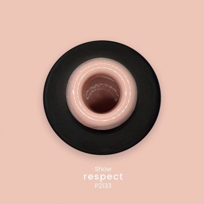Objeto cilíndrico rosa com base preta e texto 'Show respect P2133' num fundo rosa claro