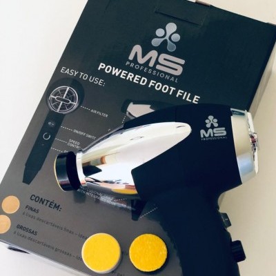 Lima elétrica para pés MS Professional com discos amarelos sobre caixa preta.