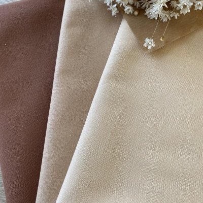 Três tecidos em tons terra com flores secas brancas