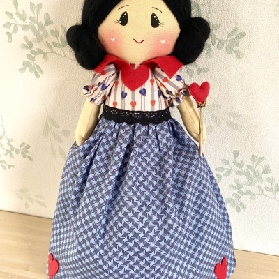 Boneca de tecido vestida com azul e branco com corações vermelhos