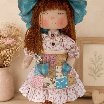 Boneca de tecido com vestido floral e chapéu azul