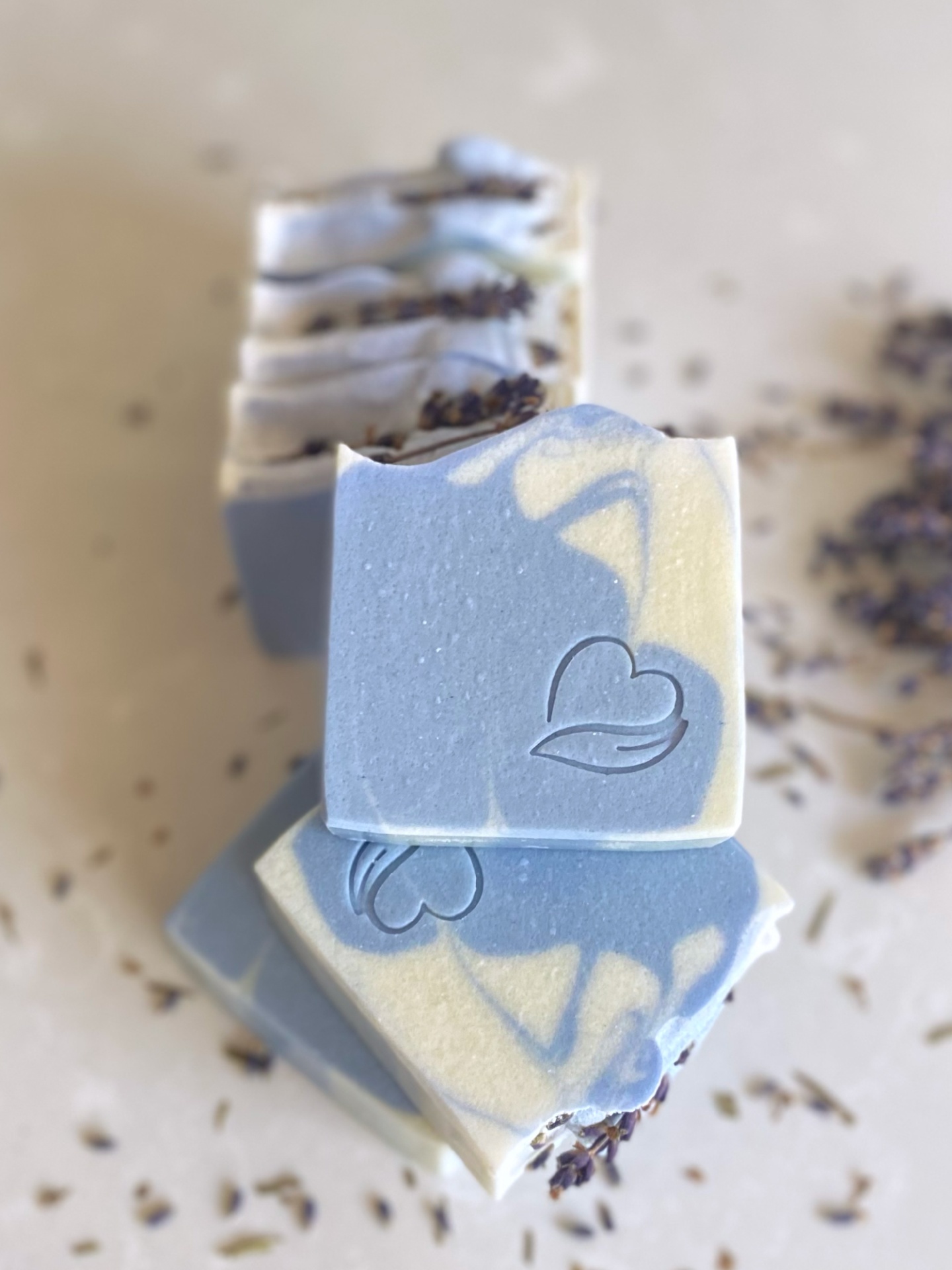 Sabonete natural de lavanda Barras de sabão azul e creme com desenho de coração e folha e flores secas em fundo neutro