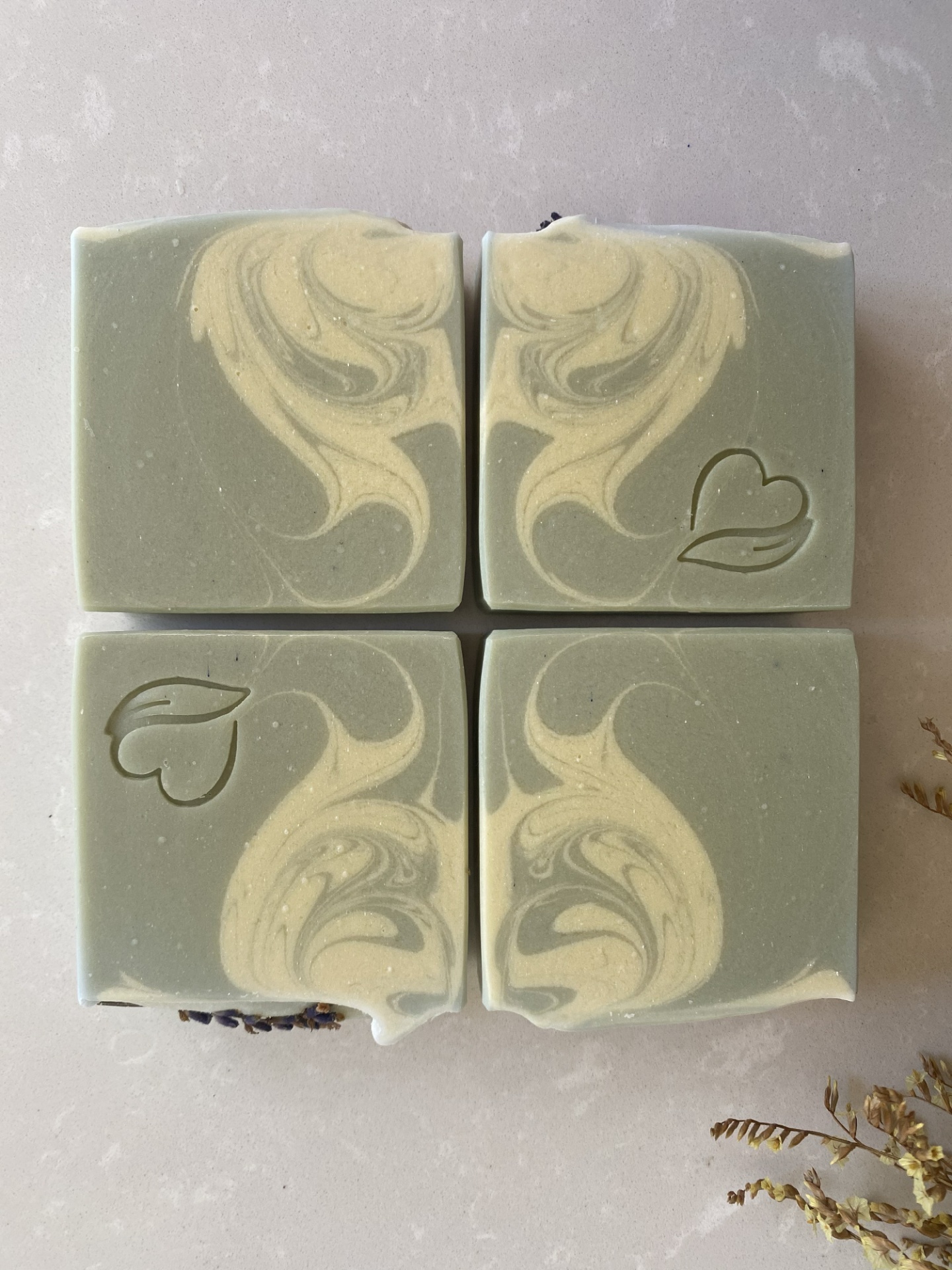 sabonete natural de lavanda e alecrim Quatro sabonetes verdes com padrão creme e símbolo de coração e folha