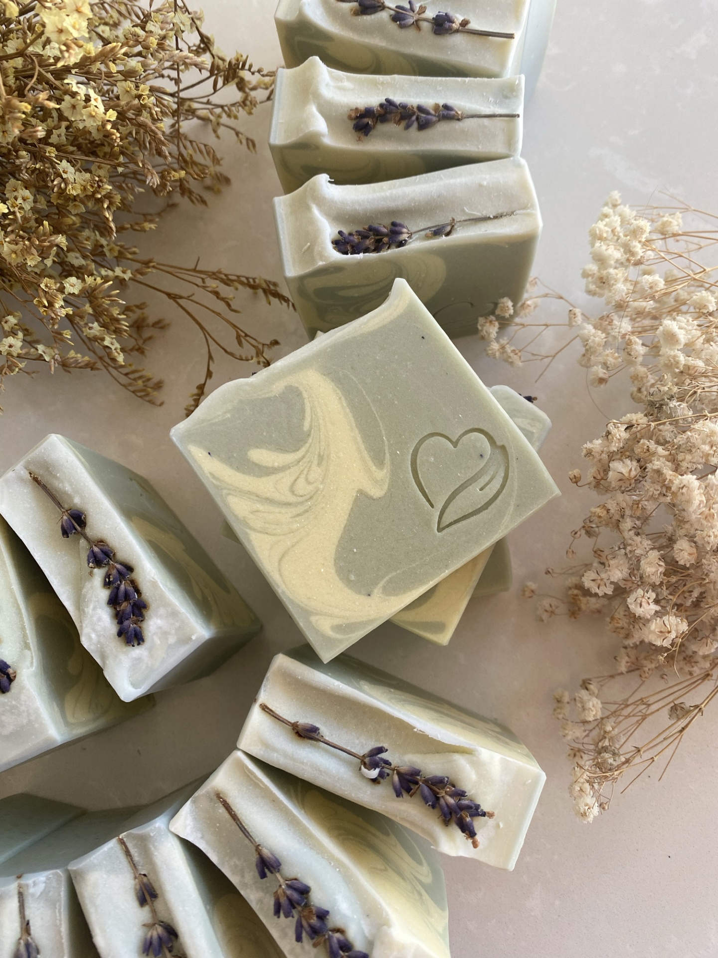 sabonete natural de lavanda e alecrim Sabonetes verdes e creme com flores secas e coração estampado.