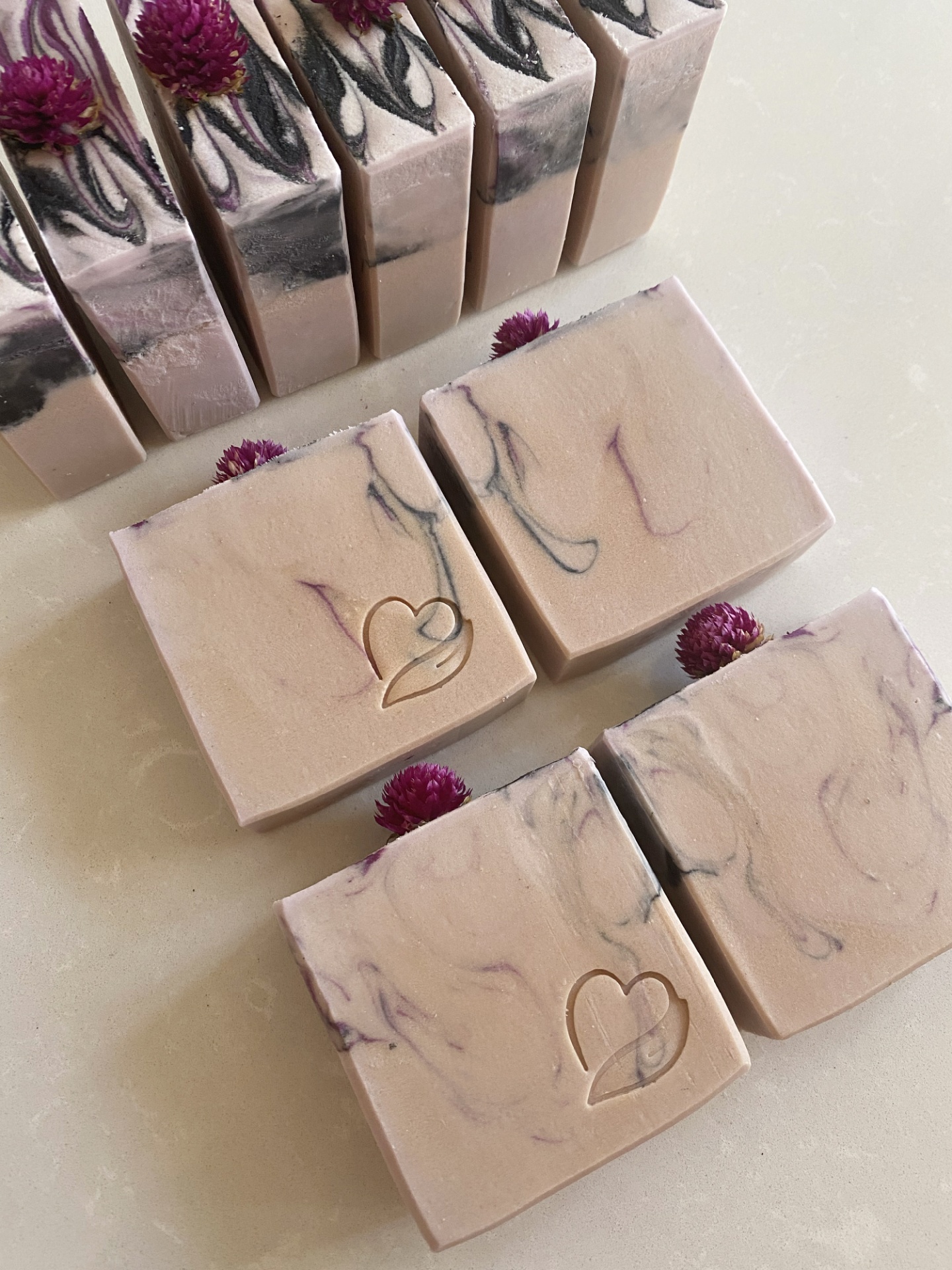 Sabonete natural Milky Rose Barras de sabonete quadradas bege com padrões roxos e pretos e flores cor de vinho.
