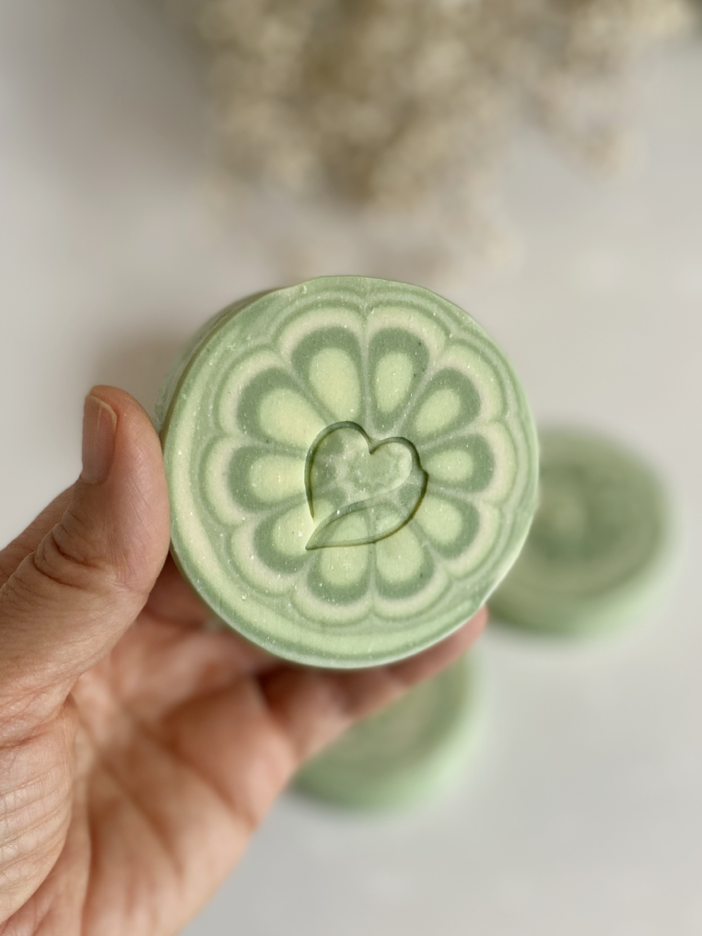 Sabonete natural de Limão Sabonete redondo verde claro com padrão floral e coração em relevo