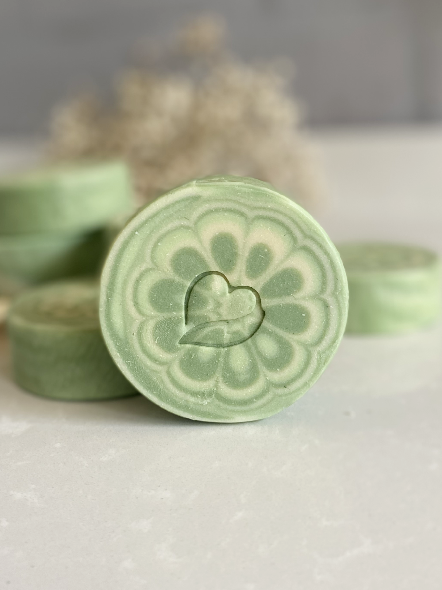 Sabonete natural de Limão Sabonete verde redondo com desenho floral e coração gravado