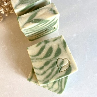 Sabonetes artesanais verde e creme com padrão marmoreado e coração gravado