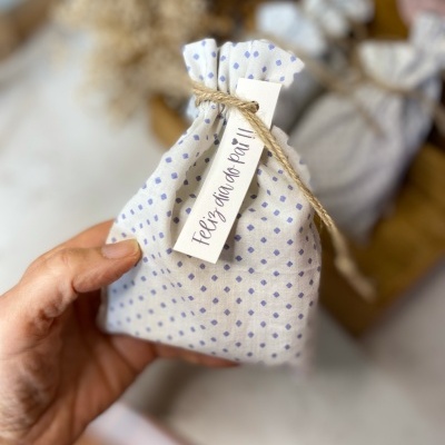 Saco de tecido branco com pontos azuis, etiqueta 'Feliz dia do Pai!!!' e cordão de juta.