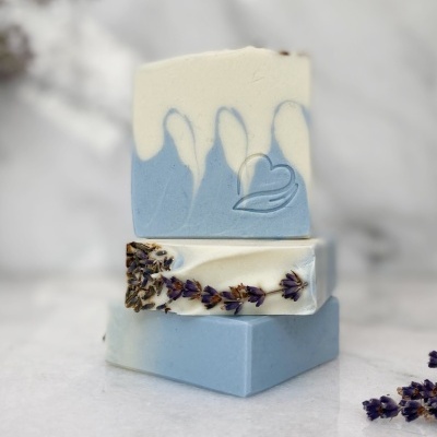 Sabonetes artesanais azuis e brancos com decoração de lavanda empilhados sobre mármore