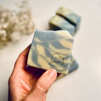 Sabonete artesanal azul e bege com selo coração na mão