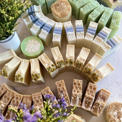 Sabonetes artesanais variados com flores secas e loofah em display circular