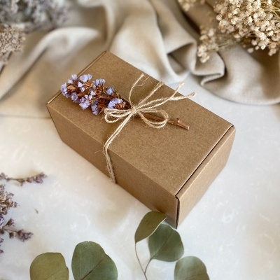 Caixa de presente em cartão castanho com corda rústica e flores secas lilás