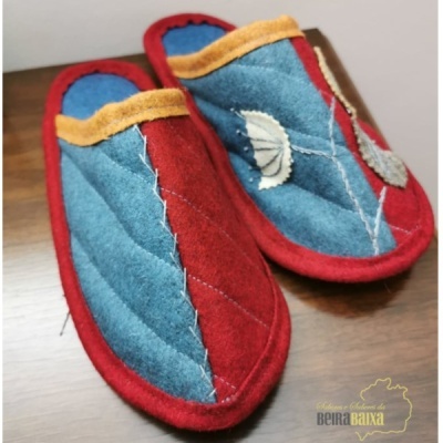 Chinelos de tecido azul e vermelho com bordados de folhas brancas