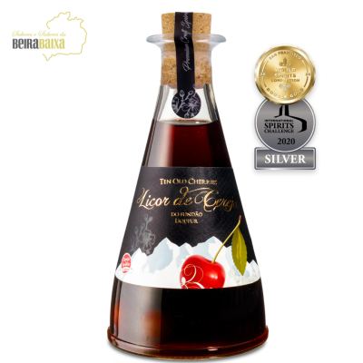 Garrafão de licor de cereja com rótulo preto e cereja vermelha, tampa de cortiça e medalhas dourada e prata ao lado