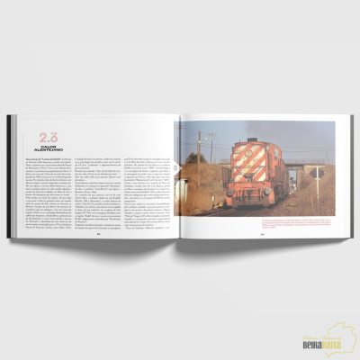 Livro aberto com texto e fotografia de locomotiva vermelha com riscas brancas.