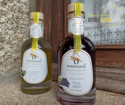 Dois frascos pequenos de azeite e vinagre com rótulos brancos e detalhes dourados