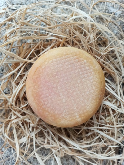 Queijo redondo amarelo sobre palha seca