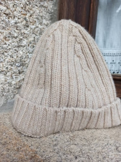 Gorro de malha bege claro com padrão de trança e dobra na aba