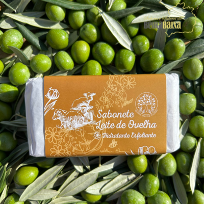 Sabonete Leite de Ovelha com embalagem castanha e branca sobre azeitonas verdes e folhas de oliveira