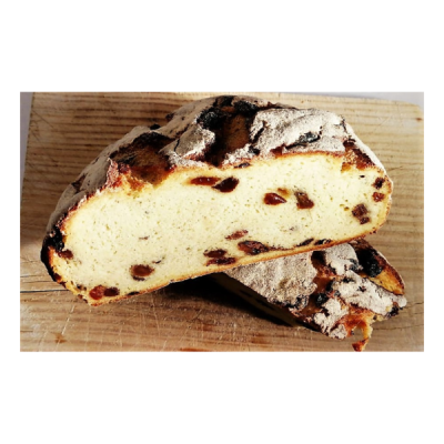 Pão rústico com passas partido sobre tábua de madeira