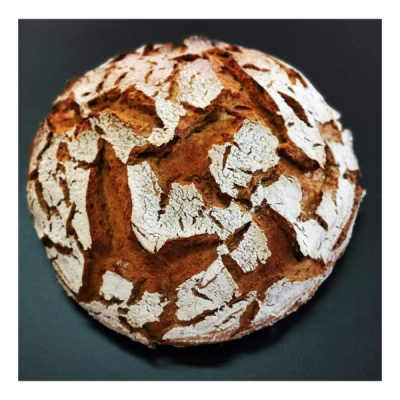 Pão redondo de crosta rústica e rachada com fundo escuro