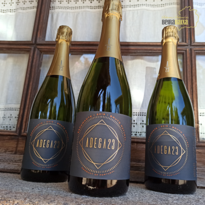 Três garrafas de vinho espumante ADEGA23 com rótulo preto e dourado