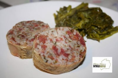 Prato com duas rodelas de butelo recheado e grelos cozidos