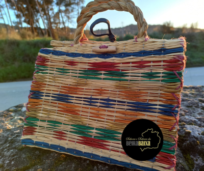 Mala artesanal de palha multicolor com padrão geométrico e fecho em corda