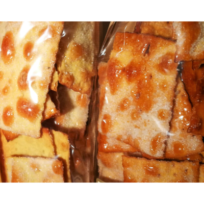 Bolachas quadradas crocantes douradas em embalagem plástica